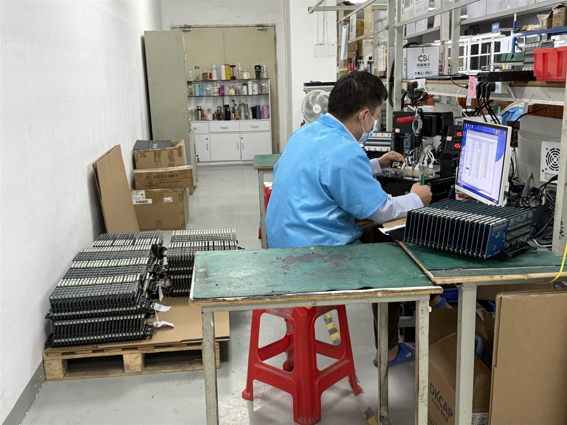 Operator reviewing PCB assembly inspection results at a production workstation