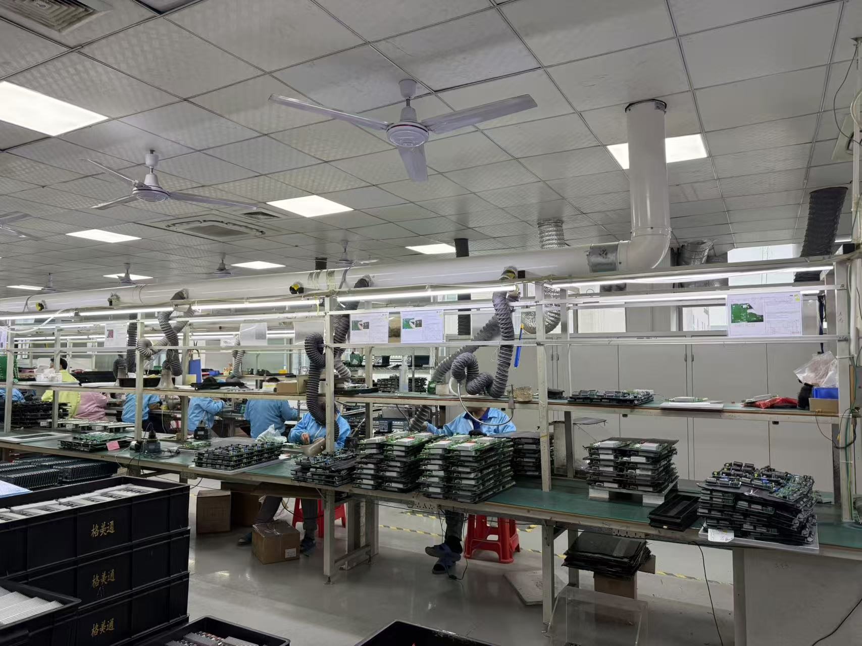 Technicians assembling and inspecting circuit boards at controlled workstations