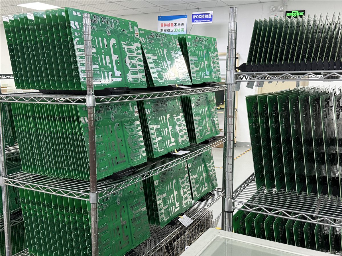 Representative factory photo of fabricated PCB panels held in inspection racks
