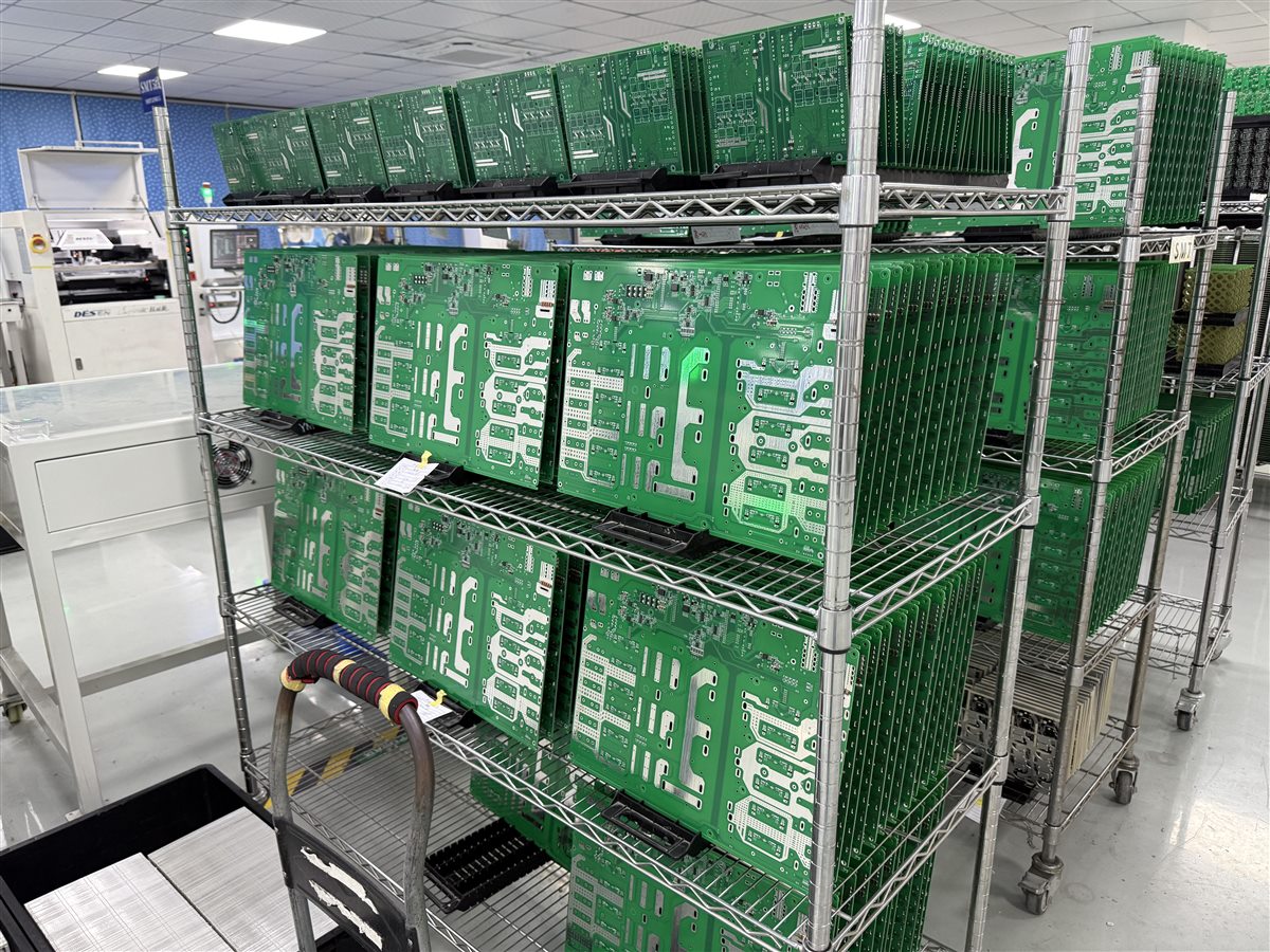 Representative factory photo of fabricated PCB panels staged in a production rack before assembly
