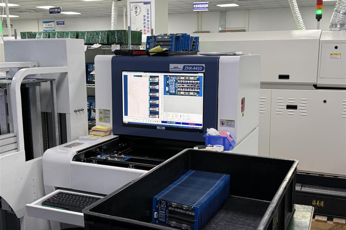 Automated optical inspection equipment beside racks of assembled circuit boards