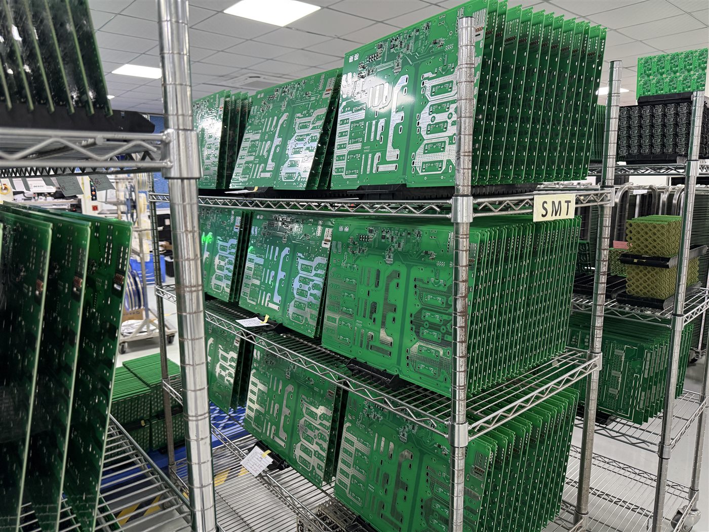 Representative factory photo of fabricated PCB panels held in production racks before assembly
