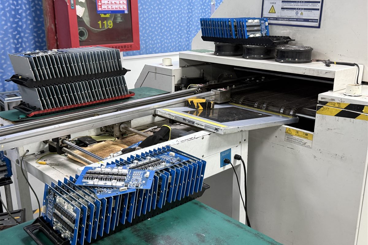 Assembled circuit boards staged beside production equipment