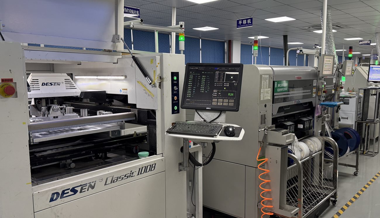 Real factory photo of SMT placement and board-transfer equipment on a PCB assembly line