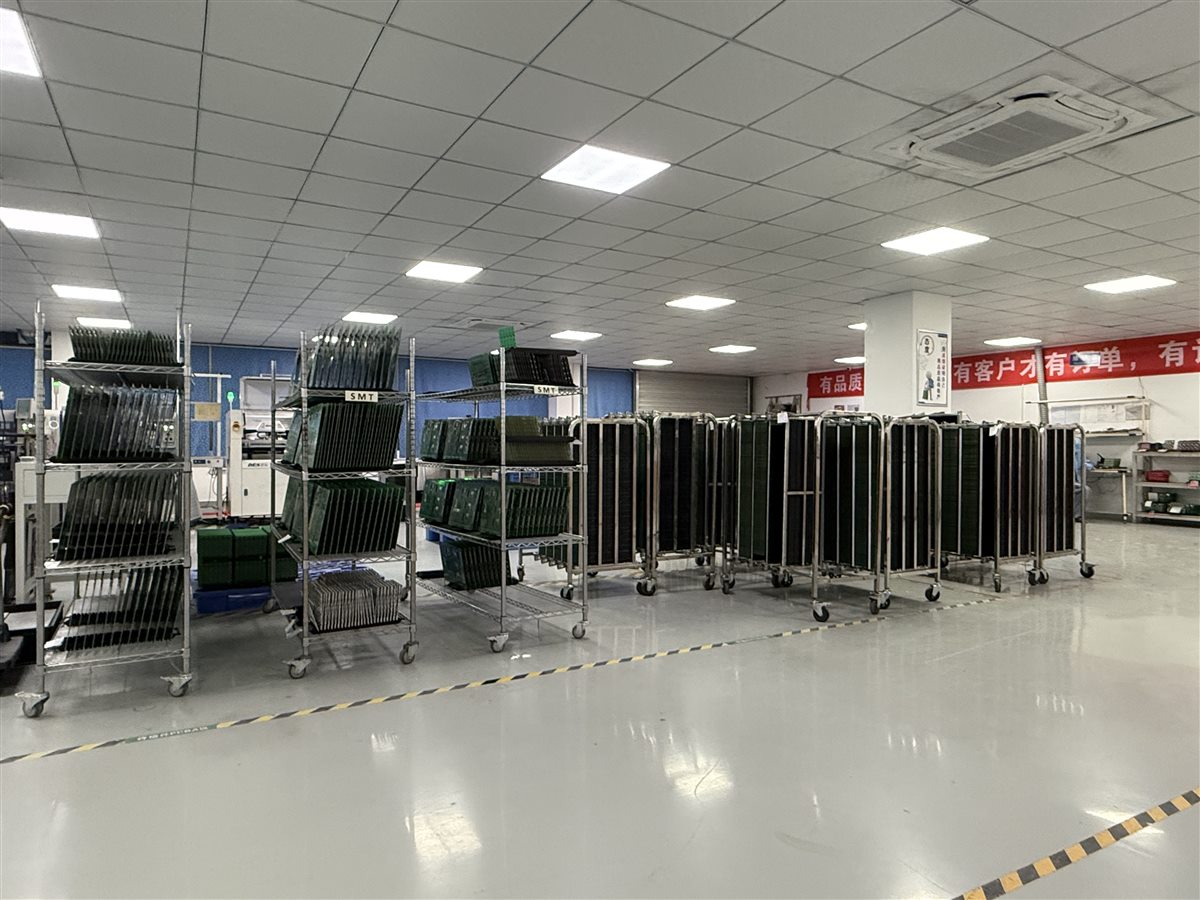 Representative PCB panels staged in factory racks before assembly