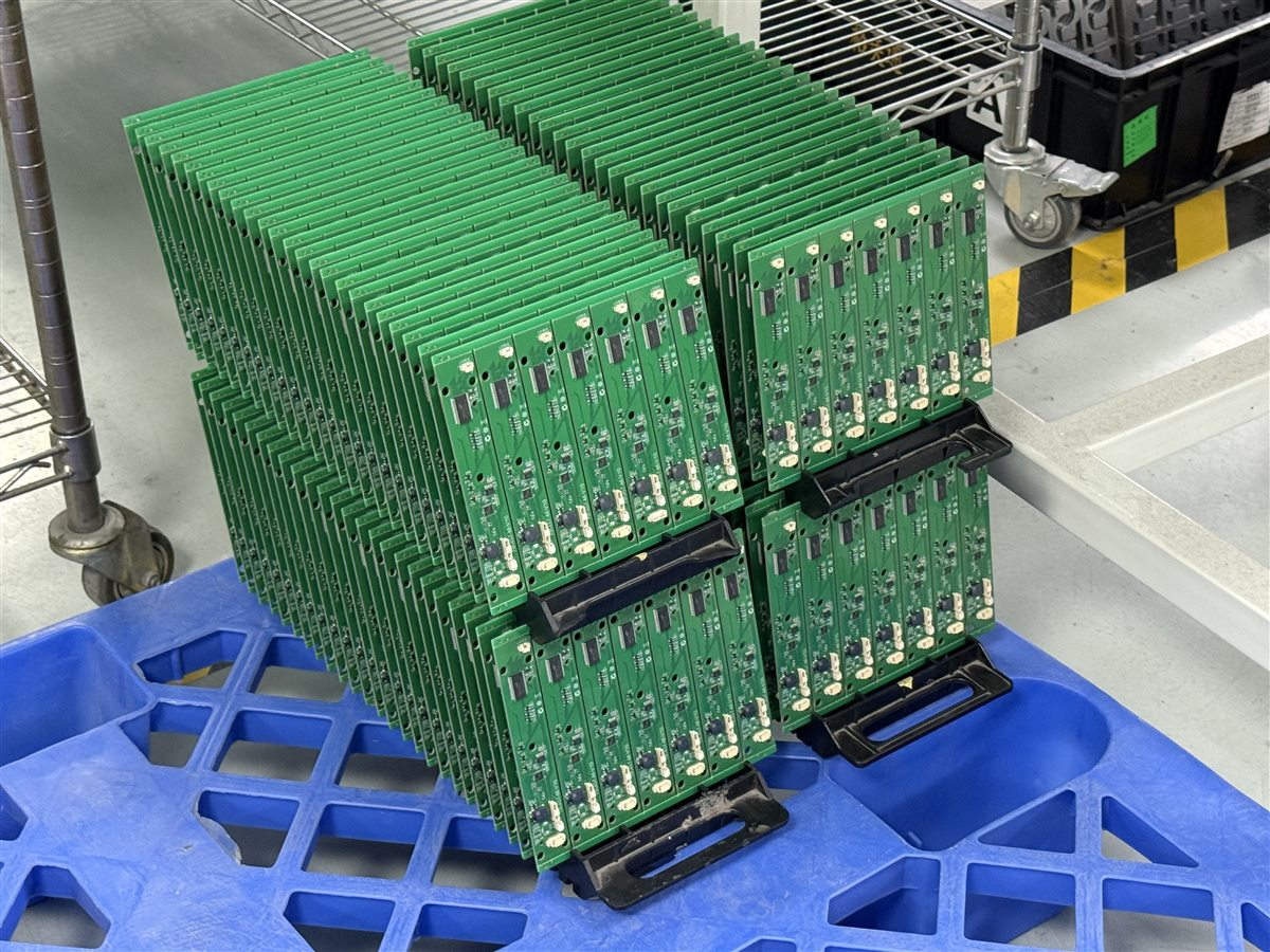 Representative assembled PCBs in factory racks; coating status not identified
